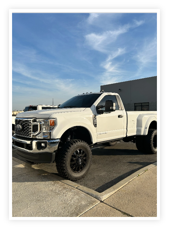 Auto Repair Services in Chino, CA at Domestic Diesel & Auto Services image of white super duty pickup truck parked outside of shop area