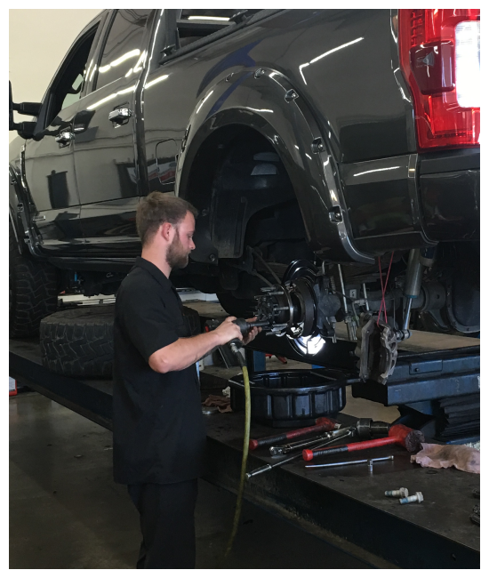 brake repair and service near me in Chino, CA at Domestic Diesel and Auto Services image of technician performing brake repairs on black truck on lift in shop