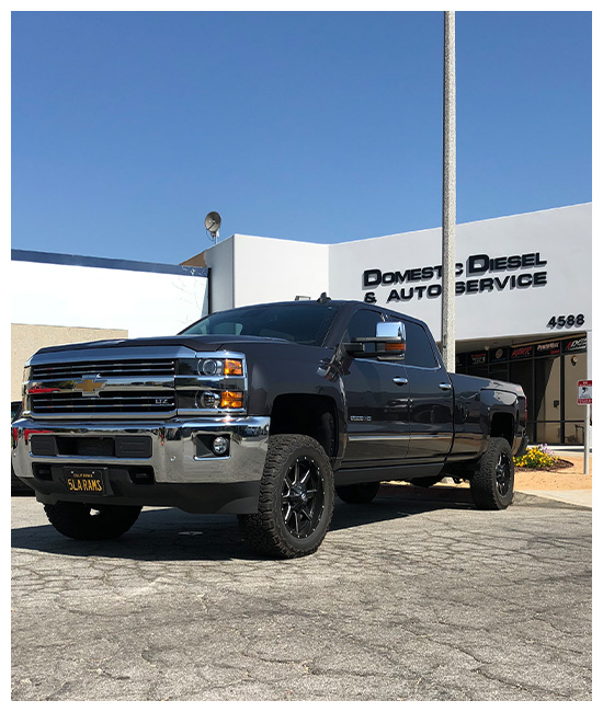 Duramax Engine Oil Leak Repair near me in Chino, CA with Domestic Diesel and Automotive Services. Image of a black Chevrolet Silverado 2500HD LTZ parked in front of Domestic Diesel & Automotive Service, after undergoing expert Duramax engine oil leak repair performed by master mechanics in Chino, CA.