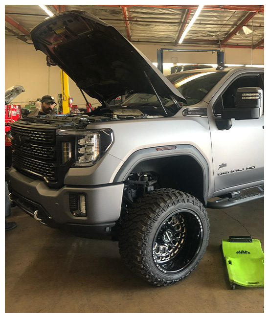 Gas Truck Repairs & Maintenance near me in Chino, CA with Domestic Diesel and Automotive Services. Image of a GMC Sierra 2500HD with an open hood undergoing repairs & maintenance.