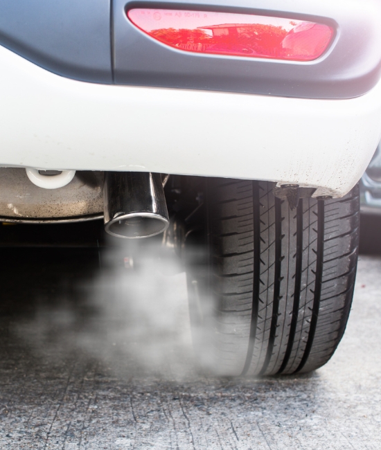 Emission System Repair and Services in Chino, CA with Domestic Diesel and Automotive Services. Close-up image of car exhaust emitting smoke, highlighting emission system repair and services.