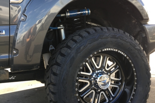 Suspension Repair and Services in Chino, CA with Domestic Diesel and Automotive Services. Close-up image of a tire showing the suspension of a Ford Platinum F250 undergoing truck repair.