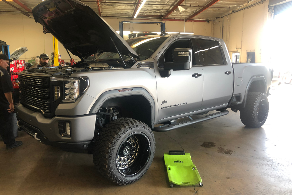 Diesel truck repair in Chino, CA by Domestic Diesel. An auto repair shop with a diesel truck undergoing inspection and repair, highlighting the importance of addressing common issues like brake wear, water pump failures, and check engine light alerts for maintaining performance and longevity during summer.