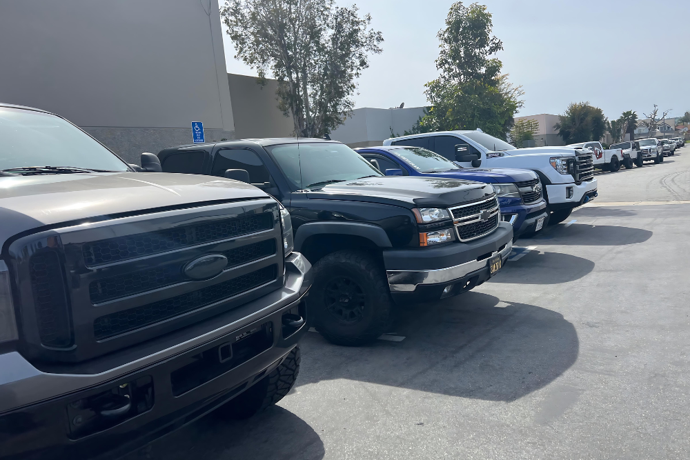 Truck Service in Chino, CA by Domestic Diesel and Auto Service. Image showing a lineup of trucks, including Ford and Chevrolet models, parked in a row, highlighting the strong presence of these popular trucks in the automotive industry.