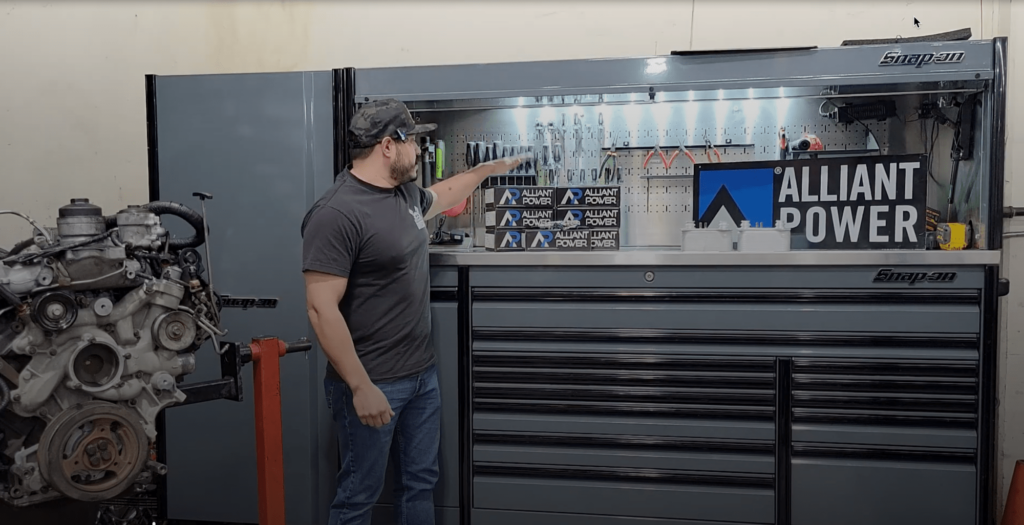 Alliant Power product review with ford diesel repair specialists Domestic Diesel & Auto Services in Chino, CA. Image of mechanic at shop near engine, tool box, and alliant power parts.